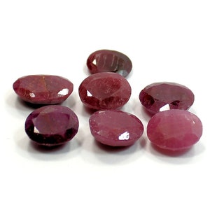 Peut inclure: Sept pierres précieuses de forme ovale dans différentes nuances de rose et de rouge. Les pierres précieuses sont lisses et polies, avec un léger éclat.
