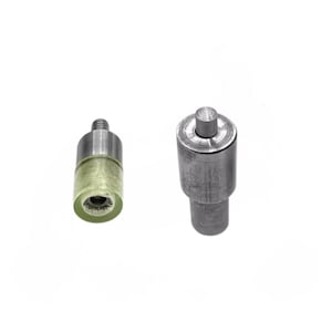 May include: Two metal tool components for a press machine. The left piece features a cylindrical silver metal top with a threaded screw and a translucent pale green plastic base. The right piece is a solid silver metal punch tool with a central pin.