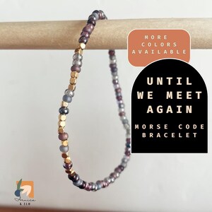 May include: A gold, silver, and burgundy beaded bracelet with the text "Until We Meet Again" and "Morse Code Bracelet".