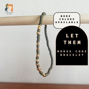 May include: A green and gold beaded bracelet with the text "LET THEM" and "MORSE CODE BRACELET".
