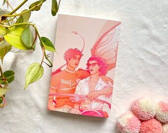 May include: A postcard featuring an illustration of two people, one with butterfly wings, in shades of pink and orange. The text "Road Trip, just keep driving" is on the shirt of one person. The background is a gradient of pink and peach.