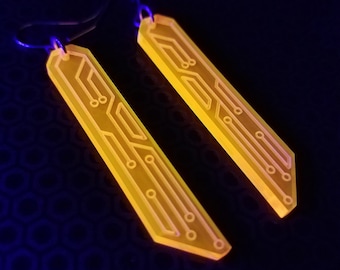 May include: A pair of yellow glow-in-the-dark earrings shaped like circuit boards.