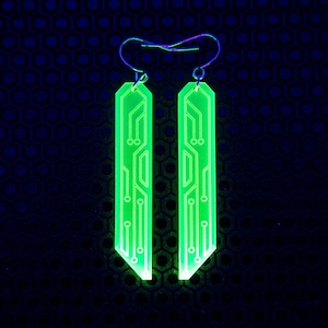 May include: A pair of green glow-in-the-dark earrings with a circuit board design.