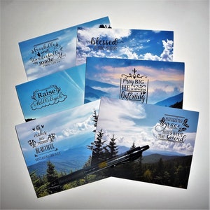 May include: Six inspirational cards with mountain scenery and religious quotes. The quotes include "Fearfully and Wonderfully Made", "Blessed Beyond Measure", "Raise a Hallelujah", "He Makes All Things Beautiful", "Pray Big He is Always Listening", and "Amazing Grace How Sweet the Sound".