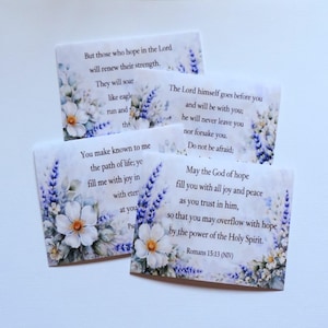 Peut inclure: Quatre cartes rectangulaires avec des motifs floraux et des écritures. Chaque carte présente un verset biblique différent dans une police délicate, entouré de fleurs et de brins de lavande de style aquarelle. Les cartes sont disposées en composition superposée.
