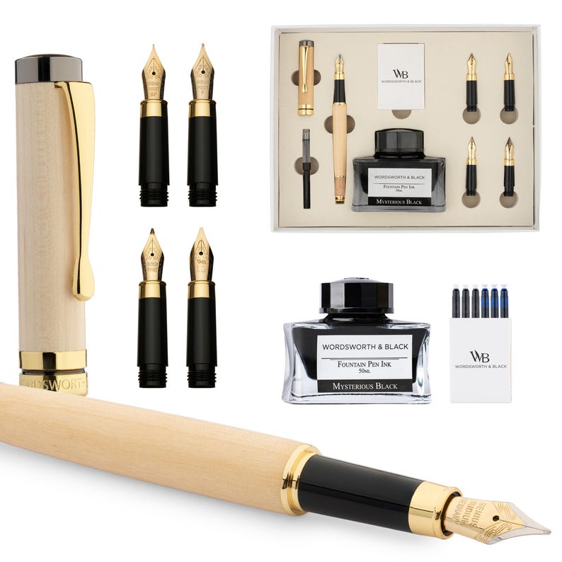 Puede incluir: Una pluma estilogr&aacute;fica de madera con detalles dorados y plum&iacute;n negro, junto con plumines de repuesto, tinta y un juego de plumas. El frasco de tinta dice "WORDSWORTH & BLACK Fountain Pen Ink Mysterious Black."