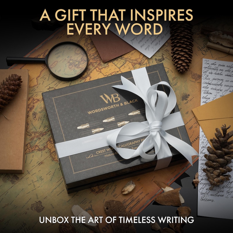 K&ouml;nnte beinhalten: Eine schwarze Geschenkbox mit wei&szlig;em Band, mit dem Text "WORDSWORTH & BLACK" und "CREST WO CALLIGRAPHY PEN". Die Box liegt auf einer Karte mit einer Lupe und Tannenzapfen. Der Text lautet "A GIFT THAT INSPIRES EVERY WORD" und "UNBOX THE ART OF TIMELESS WRITING".