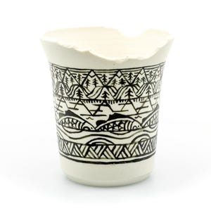 May include: A set of three ceramic mugs with a speckled, matte finish. The mugs are in shades of cream, light gray, and dark gray. Each mug has a simple, modern design and a rounded handle. The mugs are likely for coffee or tea.