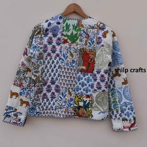 May include: A white quilted jacket with a patchwork design featuring various floral and animal prints. The jacket has long sleeves and a button closure.