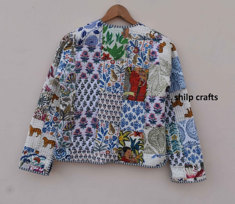 May include: A white quilted jacket with a patchwork design featuring various floral and animal prints. The jacket has long sleeves and a button closure.