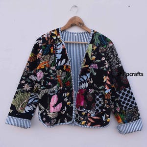 May include: A black quilted jacket with a floral print. The jacket has a V-neck and a striped lining.