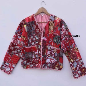 May include: A red quilted jacket with a floral and animal print design. The jacket has a V-neck, long sleeves, and a button closure. The jacket is trimmed with a white and red striped fabric.