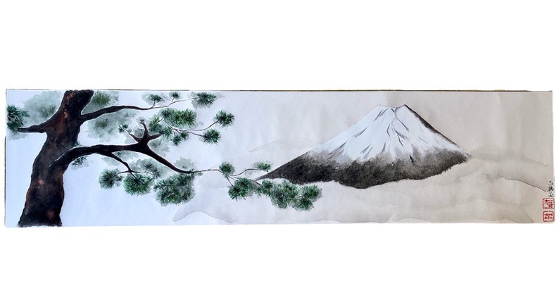 May include: Watercolor painting of Mount Fuji with a snow-capped peak, a dark tree trunk, and green foliage. The artwork is on a long, rectangular piece of paper, with Japanese characters in the lower right corner.