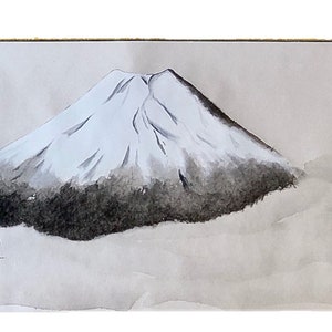 May include: Watercolor painting of Mount Fuji, a snow-capped mountain with a dark, shaded base. The artwork features a minimalist style with soft, gray tones and a touch of green foliage in the foreground. Japanese characters are in the lower right corner.