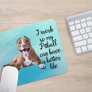 May include: A blue and white mousepad with a watercolor-style illustration of a brown and white Pitbull dog. The text "I work so my Pitbull can have a better life" is printed on the mousepad.