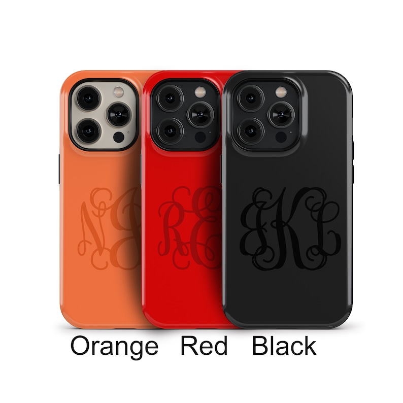 May include: Three phone cases with a monogram design. The cases are orange, red, and black.