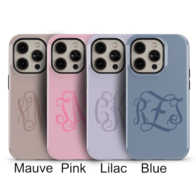 May include: Four phone cases with different colors and monogrammed initials. The cases are mauve, pink, lilac, and blue. Each case has a clear camera lens and a raised lip around the edges.