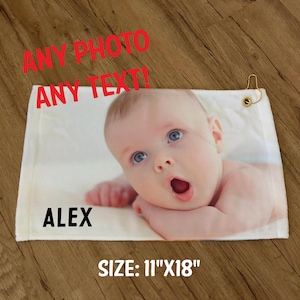 Pode incluir: Toalha de golfe branca com uma foto de um beb&ecirc; e o nome "ALEX" impresso nela. A toalha mede 11 polegadas por 18 polegadas. O texto "ANY PHOTO ANY TEXT!" est&aacute; impresso em vermelho na parte superior da toalha.