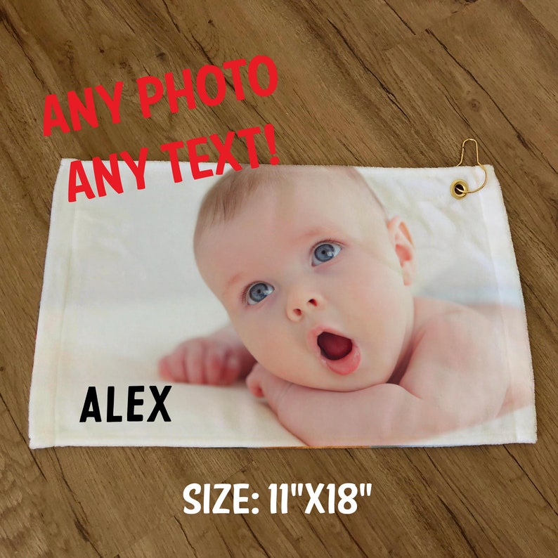 Pode incluir: Toalha de golfe branca com uma foto de um beb&ecirc; e o nome "ALEX" impresso nela. A toalha mede 11 polegadas por 18 polegadas. O texto "ANY PHOTO ANY TEXT!" est&aacute; impresso em vermelho na parte superior da toalha.
