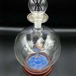 Vintage kleines Segelschiff in einer Glasflasche mit seiner Box