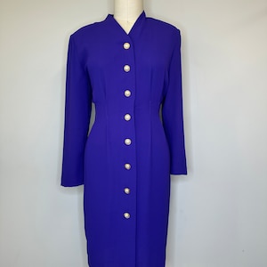 May include: A long-sleeved, royal blue dress with a mandarin collar and gold buttons down the front.