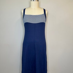 Könnte beinhalten: Ein ärmelloses Kleid in Marineblau mit einem weißen und marineblauen Streifenband über der Brust.