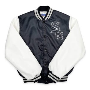 May include: A black and white satin baseball jacket with white sleeves. The jacket features a black body with a white logo on the chest and a black collar with white and gray stripes. The sleeves are white, and the cuffs and hem have black and gray stripes.