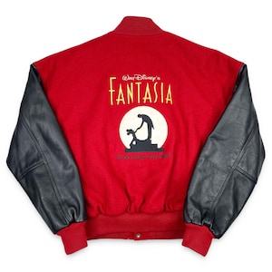 May include: Red wool jacket with black leather sleeves. The back features the Walt Disney's Fantasia logo in gold lettering, with a circular graphic of Mickey Mouse and a conductor. The jacket has red ribbed cuffs and a snap closure.