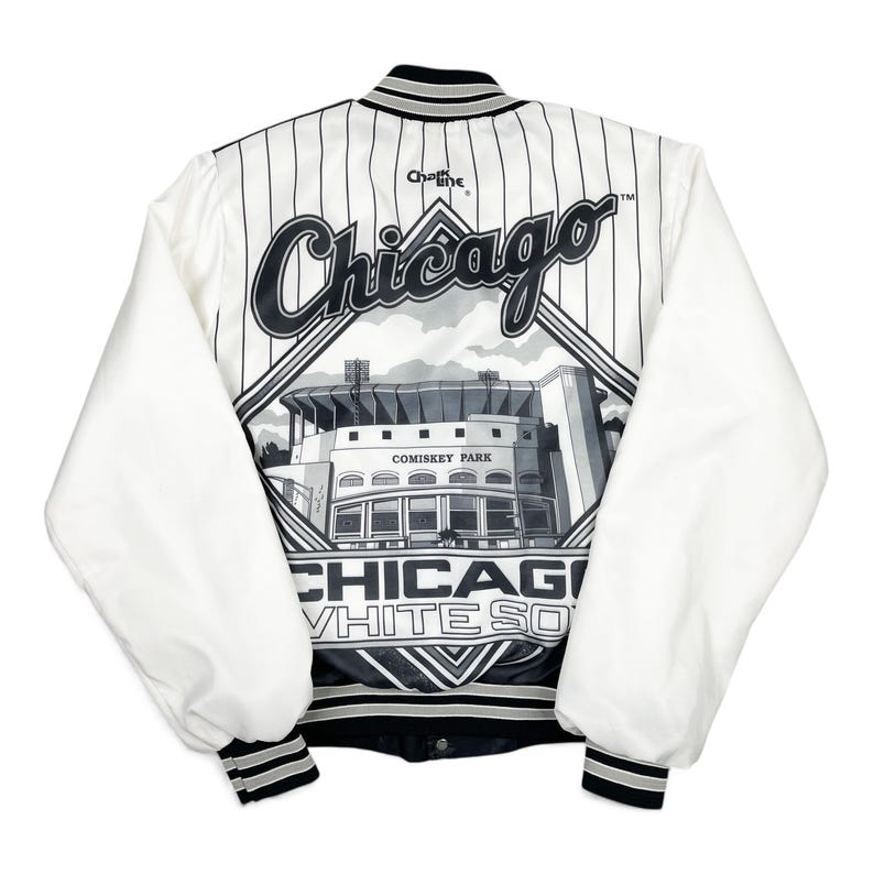 May include: White and black satin baseball jacket featuring the Chicago White Sox logo and Comiskey Park. The jacket has white sleeves and a black and white striped back with the word "Chicago" in large script.