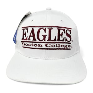 May include: White baseball cap with the word "EAGLES" in maroon block letters above "Boston College" in maroon. The cap has a curved bill and a tag attached.