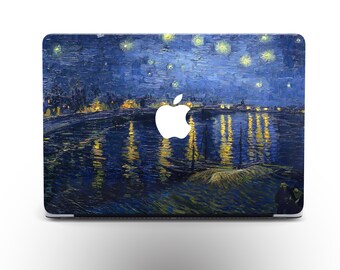 Puede incluir: Una piel para portátil con una pintura de un cielo nocturno estrellado sobre un río con un horizonte de ciudad en la distancia. La pintura está en tonos de azul, amarillo y blanco.