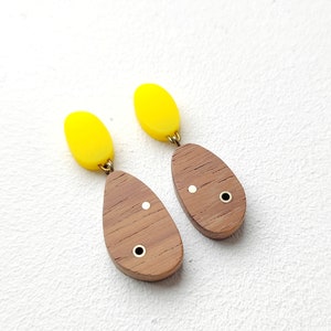 Niet bij elkaar passende abstracte ovale oorbellen met acryl- en koperen details.