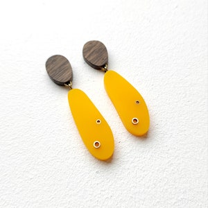 Niet-overeenkomende abstracte ovale houten hang- en hangoorbellen met mosterdgeel acryl en messing details.