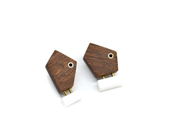 Mismatched asymmetrical wooden stud earrings with white acrylic and brass details.