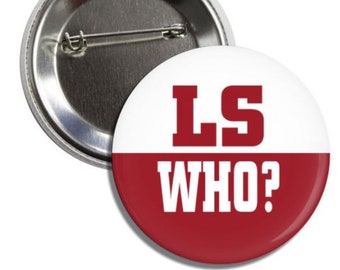 Puede incluir: Un botón blanco y rojo con el texto "LS WHO?" en letras blancas en negrita sobre un fondo rojo. Las letras "LS" están en letras rojas en negrita sobre un fondo blanco.