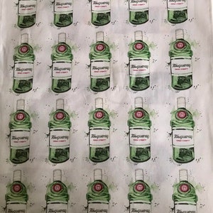 May include: White fabric with a repeating pattern of green Tanqueray gin bottles. Each bottle has a white label with black text and a red circular emblem. The bottles are surrounded by green watercolor-style accents.