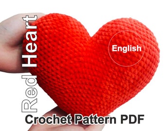 May include: A vibrant red, crocheted heart-shaped item. The image includes the text "Red Heart Crochet Pattern PDF" and the word "English" in a circle. The heart is held in a person's hands against a white background.