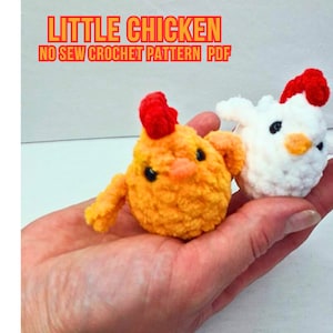 May include: Two crocheted chicken toys, one yellow and one white, with red combs. The toys are held in a person's hand. The text "LITTLE CHICKEN NO SEW CROCHET PATTERN PDF" is displayed above the toys.