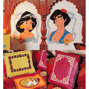 May include: Four embroidered pillow covers featuring characters from the Disney movie Aladdin. The covers feature Jasmine, Aladdin, a genie lamp, and a tiger. The covers are all in a cream color with a brown border.