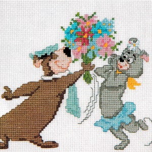 Puede incluir: Un patrón de punto de cruz con Yogi Bear y Cindy Bear, con Yogi sosteniendo un ramo de flores y Cindy con un vestido azul y una flor en el pelo.