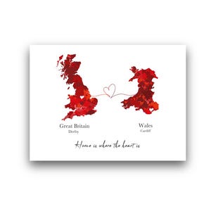 Op de afbeelding: Een witte print met rode aquarelkaarten van Groot-Brittannië en Wales, verbonden door een hartvormige lijn. Tekst luidt "Great Britain, Derby" en "Wales, Cardiff". De zin "Home is where the heart is" staat eronder.