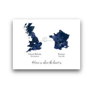 Op de afbeelding: Een print met aquarelkaarten van Groot-Brittannië en Frankrijk, verbonden door een hartvormige lijn. Birmingham is gemarkeerd op de kaart van Groot-Brittannië en Marseille op de kaart van Frankrijk. De zin "Home is where the heart is" staat onder de kaarten.