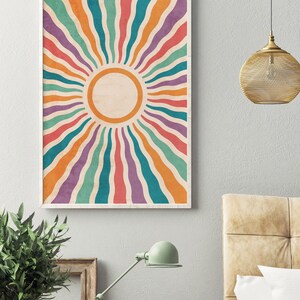 May include: A retro-style sunburst print with a white circle in the center. The sunburst is made up of colorful stripes in shades of orange, red, purple, teal, and green.