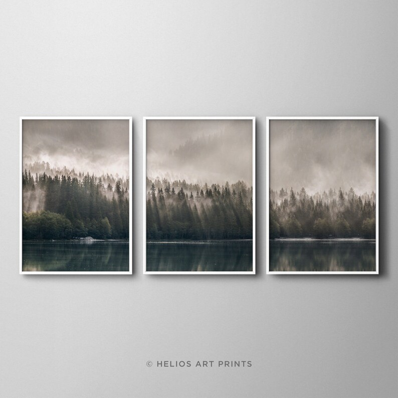 May include: A set of three framed prints depicting a misty forest scene with a lake reflecting the trees and sky. The prints are in a muted colour palette of browns and greys.