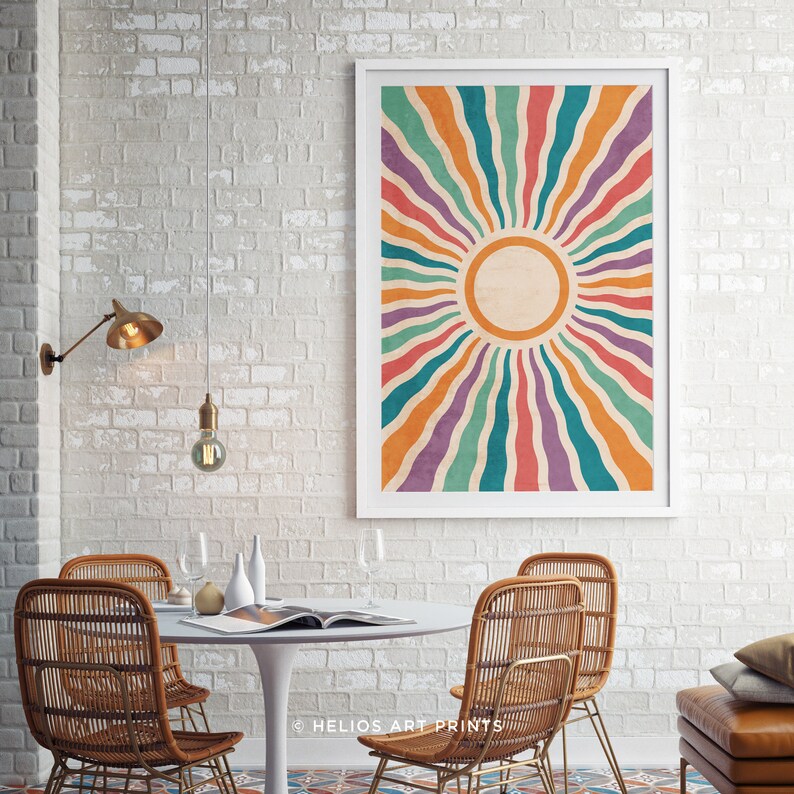 May include: A framed print with a retro sunburst design featuring colorful stripes in shades of orange, red, teal, purple, and yellow. The sunburst design is centered on a white circle with a textured background.