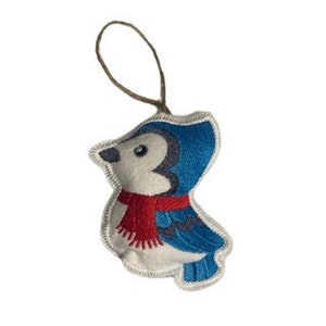 Op de afbeelding: Een witte vilten ornament met een geborduurde blauwe gaaien die een rode sjaal draagt. De ornament heeft een bruine touwlus om op te hangen.