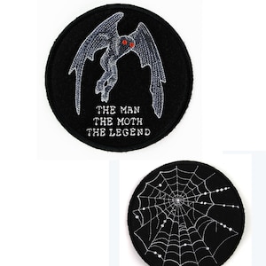 May include: Two black round patches. The top patch features a detailed embroidered moth with red eyes and the text "THE MAN THE MOTH THE LEGEND" in white. The bottom patch shows a white spiderweb design.