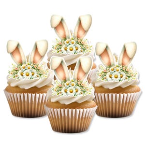 May include: Three cupcakes decorated with edible images of bunnies and flowers. The cupcakes are white with brown wrappers. The bunny images are white with pink ears and the flowers are white with yellow centers.