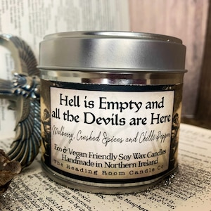 Puede incluir: Una vela en una lata de plata con una etiqueta negra que dice "Hell is Empty and all the Devils are Here". La etiqueta también incluye el texto "Mulberry, Crushed Spices and Chilli Pepper", "Eco & Vegan Friendly Soy Wax Candles", "Handmade in Northern Ireland", y "The Reading Room Candle Co.".