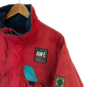 May include: Red Yamaha jacket with a blue and teal accent. The jacket has two patches that say "All Weather AWE Emergency" with the Yamaha logo.